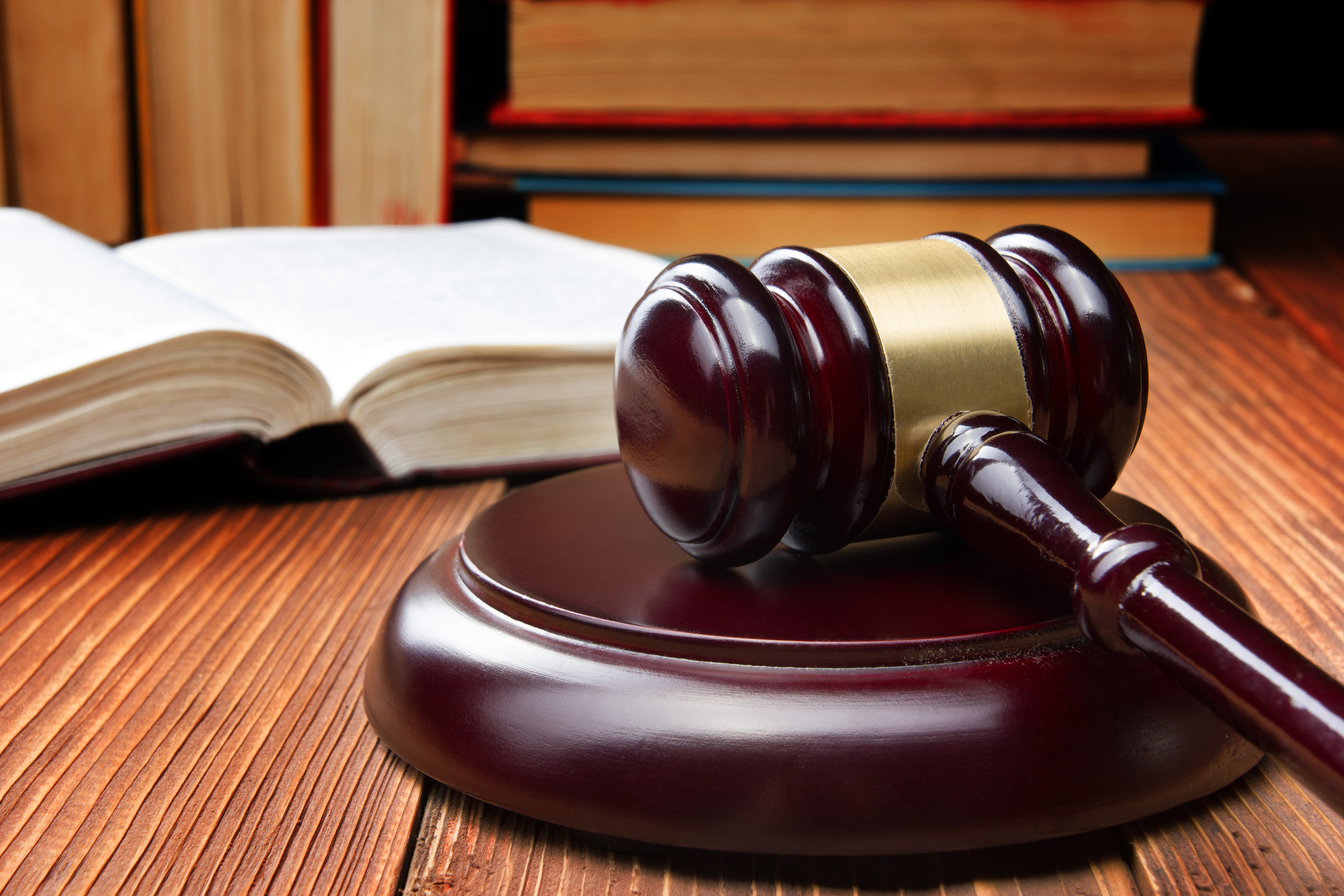 Law book with wooden judges gavel on table in a courtroom or law