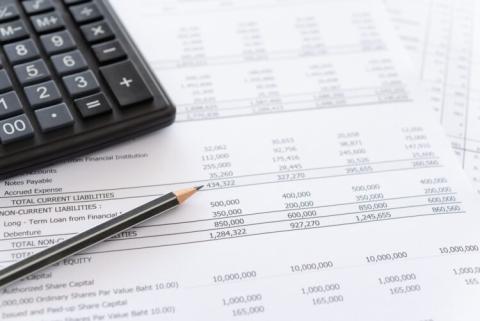 balance sheet and calculator on accountant's desk.