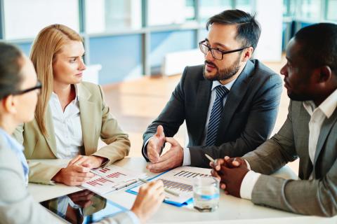 Business people in suits talking at meeting