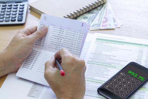 Reviewing bank passbook saving account balance and cash flow statement analysis for a return on investment, ROI, and business performance